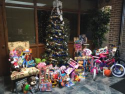 Christmas Tree with Toys for Tots collection around it.