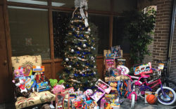 Christmas Tree with Toys for Tots collection around it.